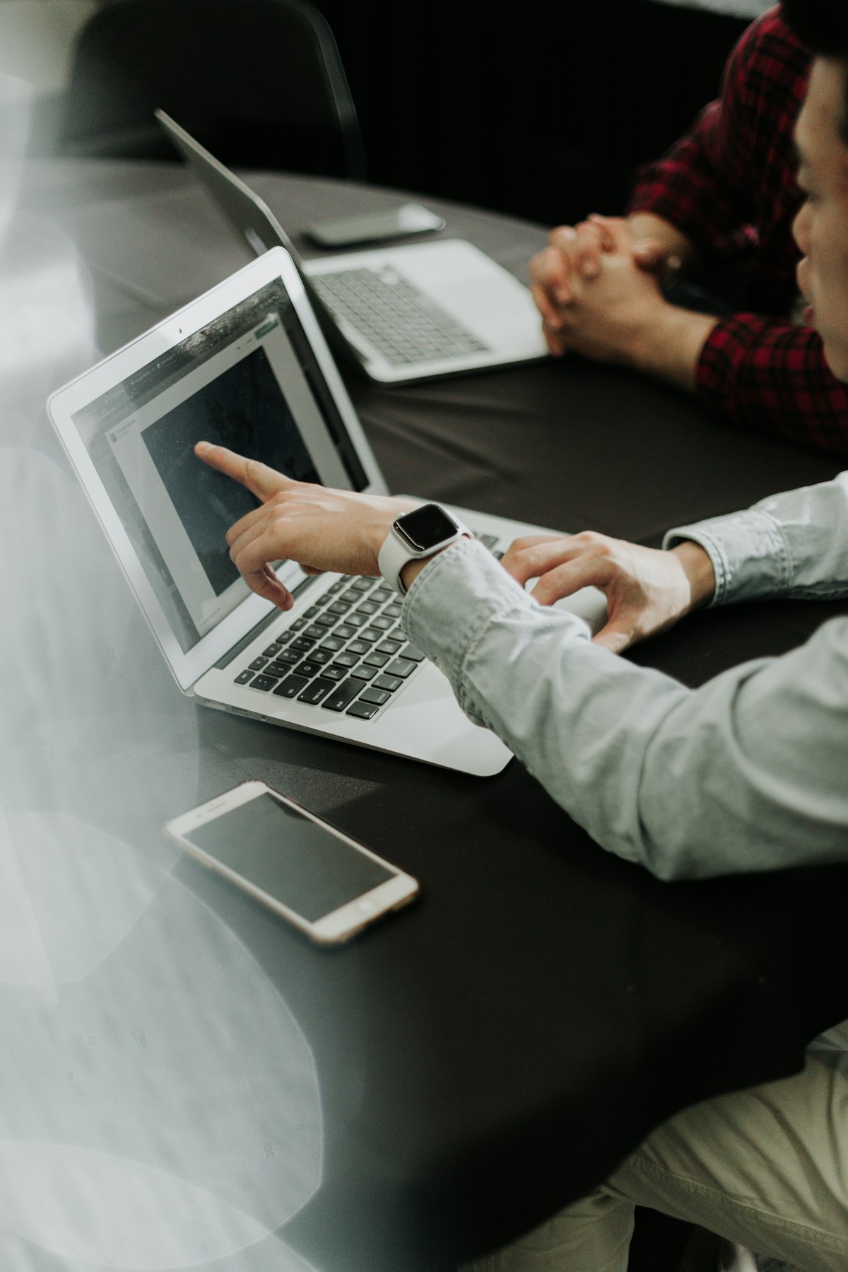 Two people collaborating at laptops, illustrative stock photography